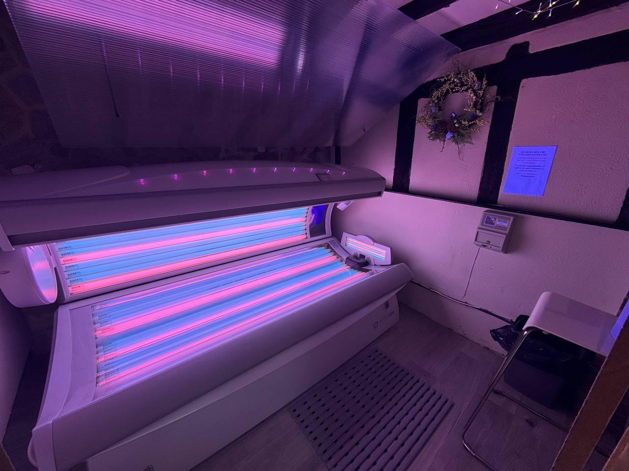 Ultrasun lie-down tanning bed with purple ambient lighting